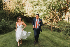 The bride and groom walking in the woods