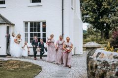 Bride and bridesmaids processing from the farmhouse