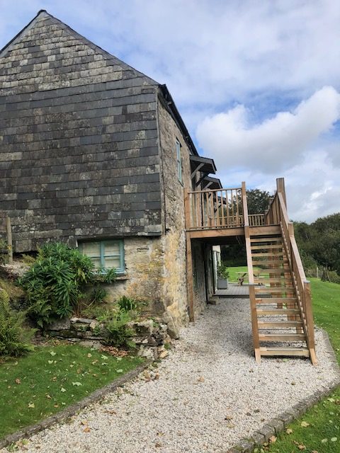 Gable end on view of Cottage Three and Five showing the wooden steps leading to the open entrance decking area outside Cottages Three and Four