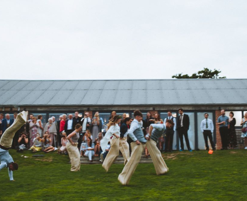 relaxed-wedding-19 A group of guests are having a sack race on the lawn in front of the Red Brick Barn